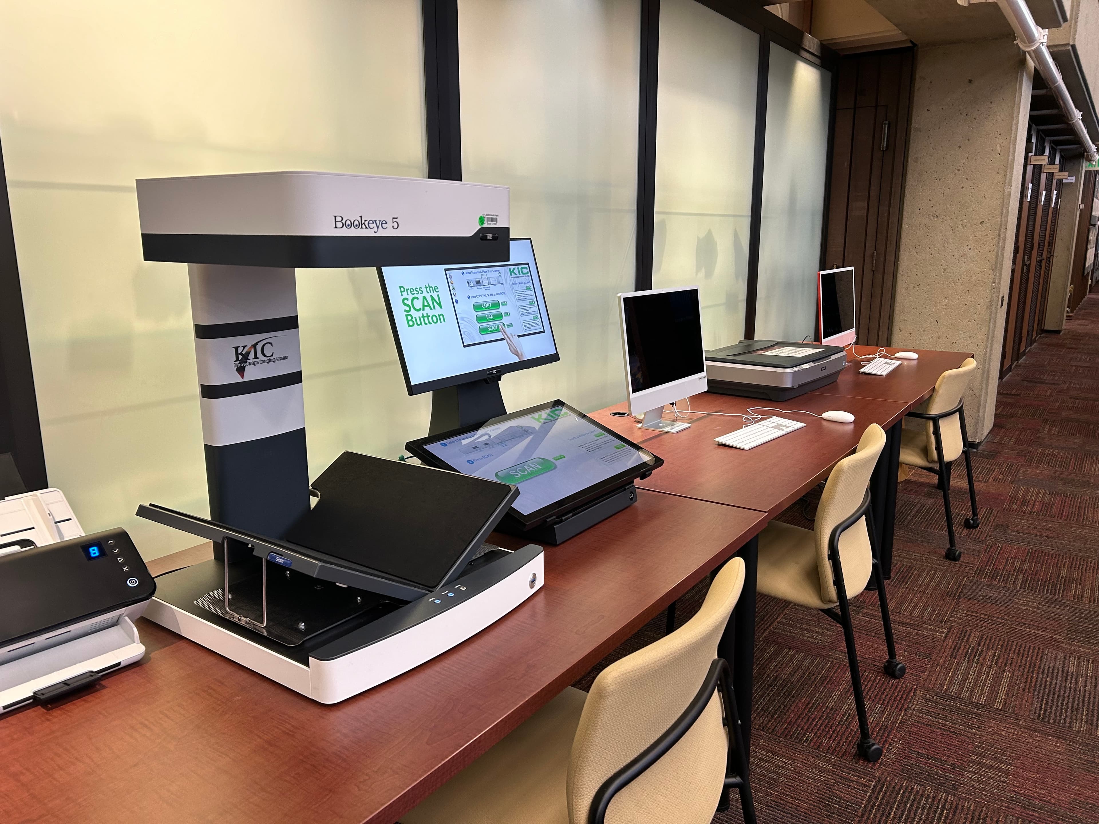 Photograph of an overhead scanner and two desktop computers.