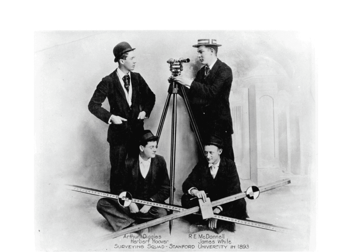 Stanford history surveying with surveying tools. Two men sitting in the front and two standing behind them.